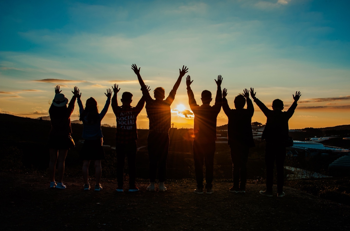 Grupo de personas reunidas al atardecer, unidas por un propósito común.